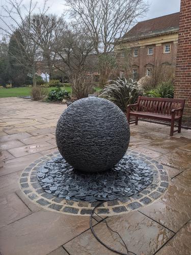 1.2m (extra large) Grey slate Watersphere™ set on a circular bed of slate chippings in Oxford University grounds.